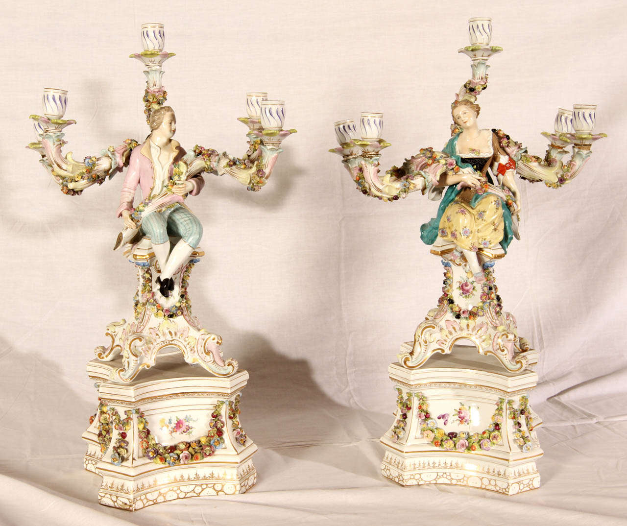 Pair of 19th Century porcelain candelabras. Couples of galant style figurines. Five light arms. Very good condition. Normal wear consistent with age and use.