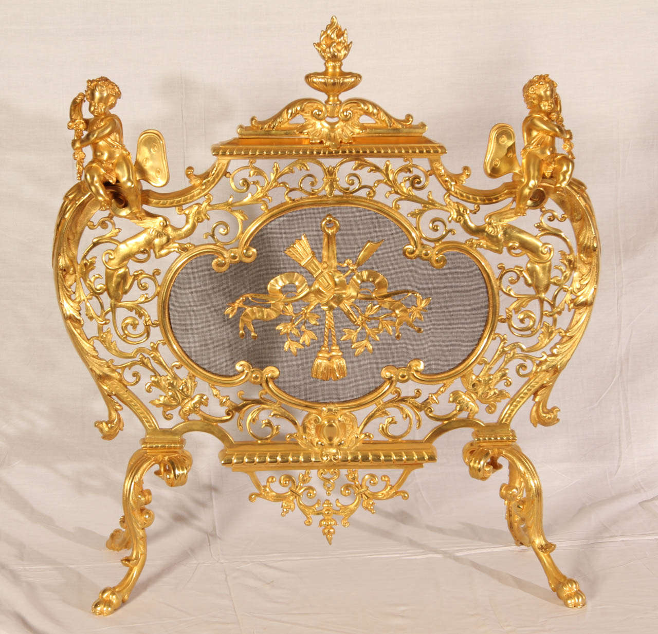 19th Century fire screen. Gilded brass and cherub decor. Very good condition. Normal wear consistent with age and use.