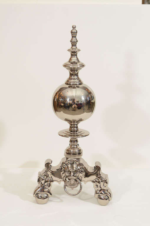 Exceptional pair of large-scale polished nickel andirons with a large sphere center and stylized lion heads.