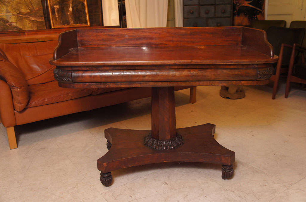 1830s-1840s American pedestal serving table in mahogany with backsplash, fluted melon feet with original casters.