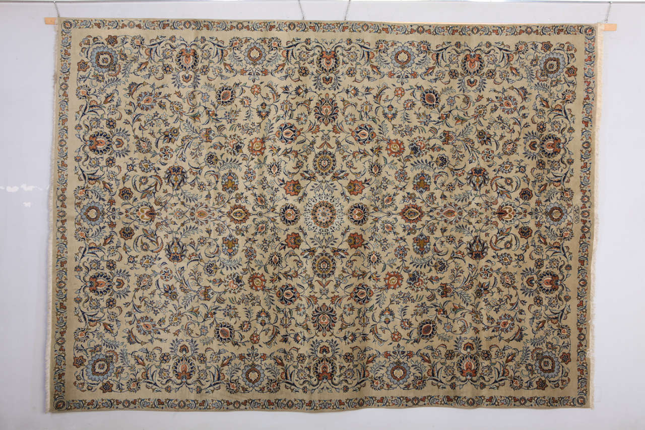 This extra fine Persian Kashan rug, made with exceptional quality wool, has a stunning field color and quality and a very sophisticated floral design. This particular rug is also signed by the Persian master Attai.