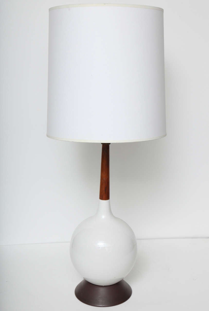 Pair of white ceramic table lamps with walnut neck and metal base. USA, circa 1960. 

Shades are not included. 

Wired for use in the U.S.; each lamp takes one standard base bulb, 75 watts max.

Dimensions (in inches):
20
