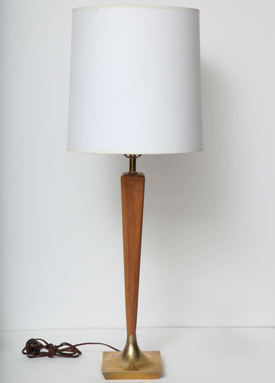 Modern walnut and brass table lamp.  USA, circa 1960.  Features a reverse tapered wood stem with sculpted brass base.  Two available; priced individually.