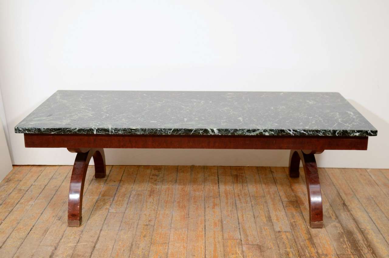 A vintage art deco coffee or cocktail table with a wood base and a black with green tones marble surface. The piece is in good vintage condition with age appropriate wear; some scratches.