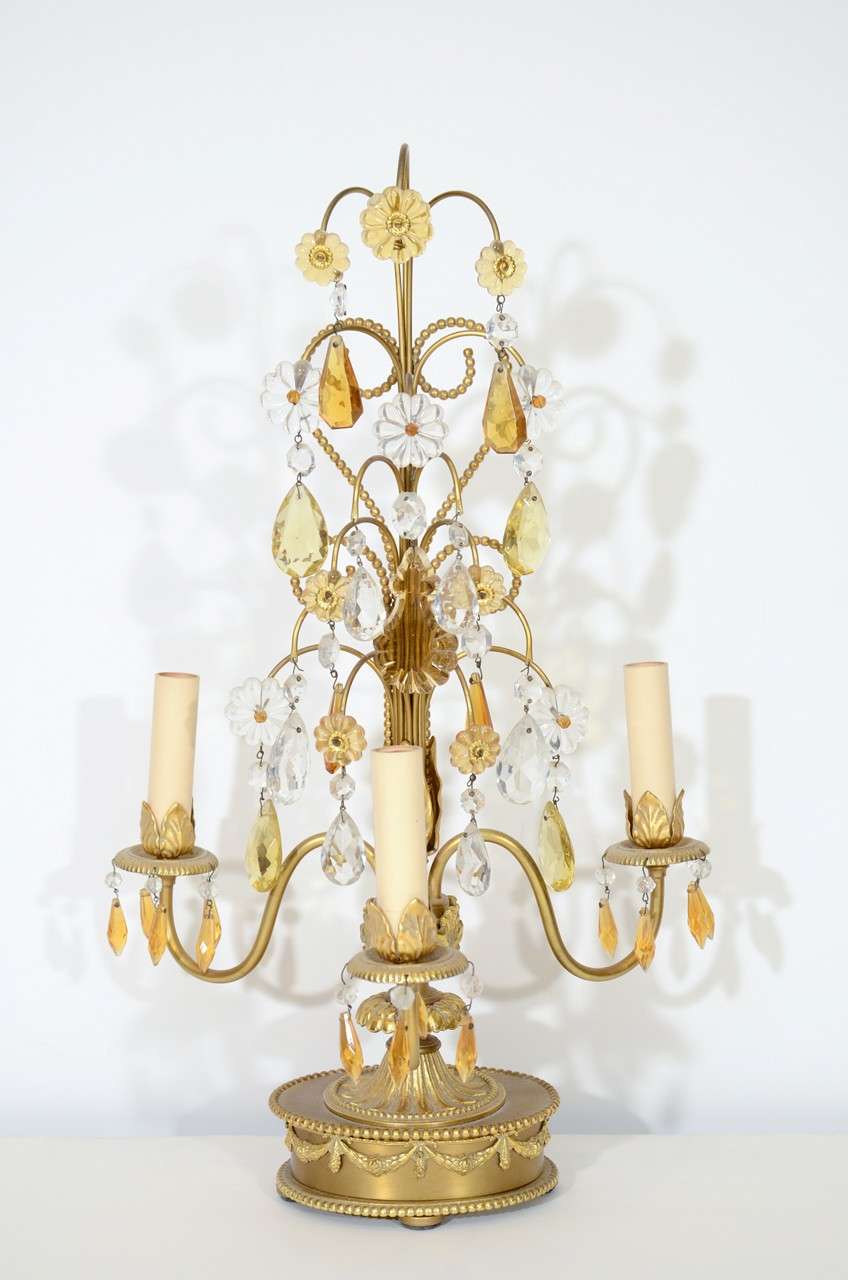 A pair of three light candelabra in brass and bronze with clear and yellow bed detailing.