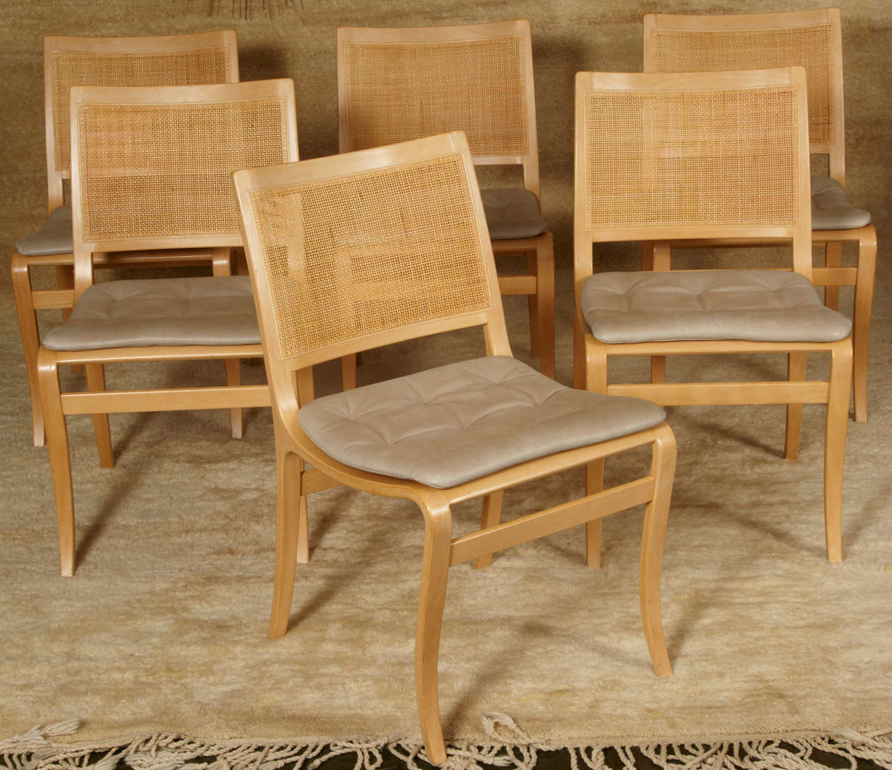 Very elegant and rare model of dining chairs designed by the swedish, Bruno Mathsson. The 'Kerstin' model has a natural birch frame, seating is loose beige leather cushions and woven cane in the back. Produced by Dux.