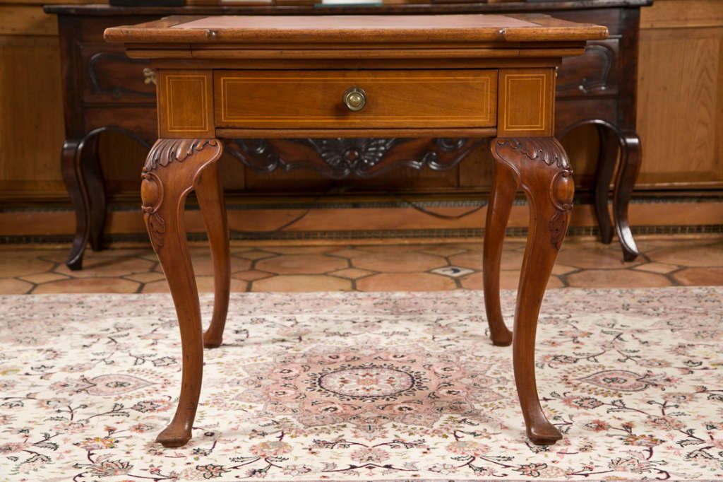 This game table from Austria has a few cards hidden up its sleeve. First, the drawer is double-sided and accessible from either side of the table. Second, reaching under any corner, one can grab the bottom of a pull-out tray which is spring loaded