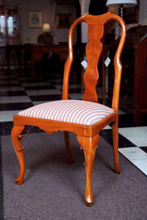 This is a custom-made, English walnut Queen Anne style dining chair with an upholstered slip seat, scalloped apron and carved, cabriole legs. Small in stature, but great in comfort for its size, this chair has the ability to bridge many stylistic