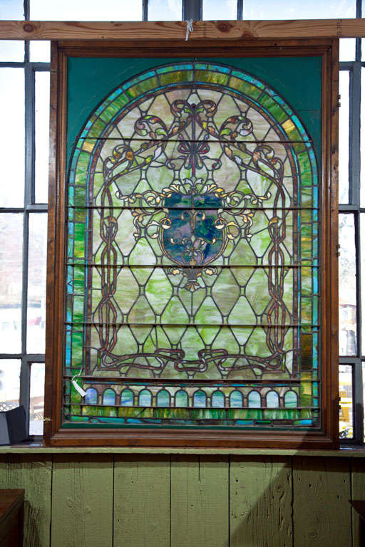 Beautiful large antique stain glass window.  Decorative piece with shield motif in center of panel.