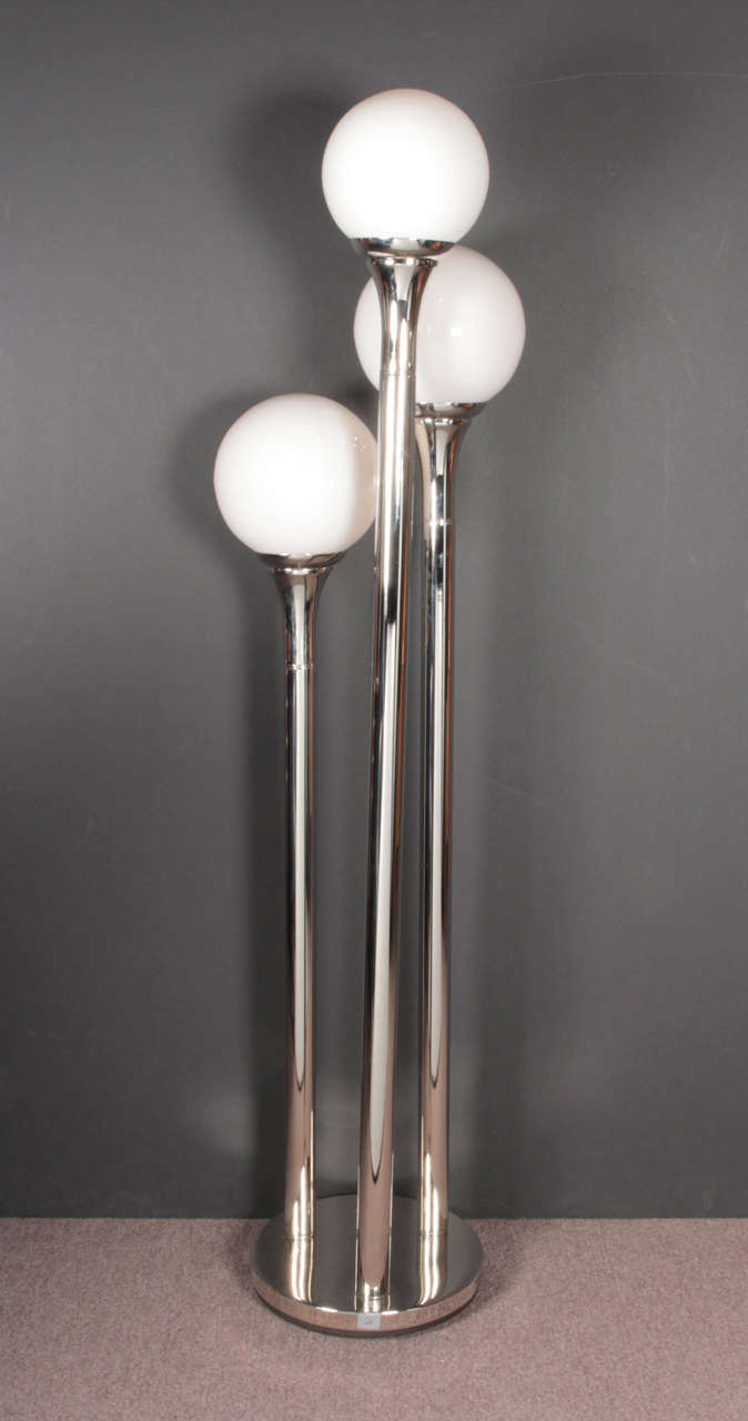 An interesting table / floor lamp featuring tubular flanged chrome posts of varied heights bearing illuminated opaque white globes.
The base measures 11 1/2