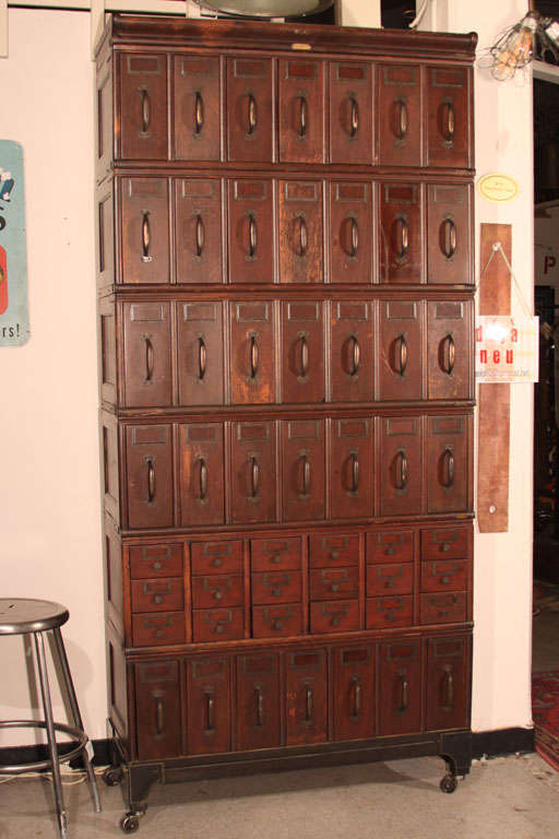 Quarter sawn oak with original, red mahogany finish, vertical, stacking file cabinet.  53 metal bodied drawers,  custom steel industrial base, steel sheet top, from LA County Courthouse.  Comes apart into eight pieces, original hardware.