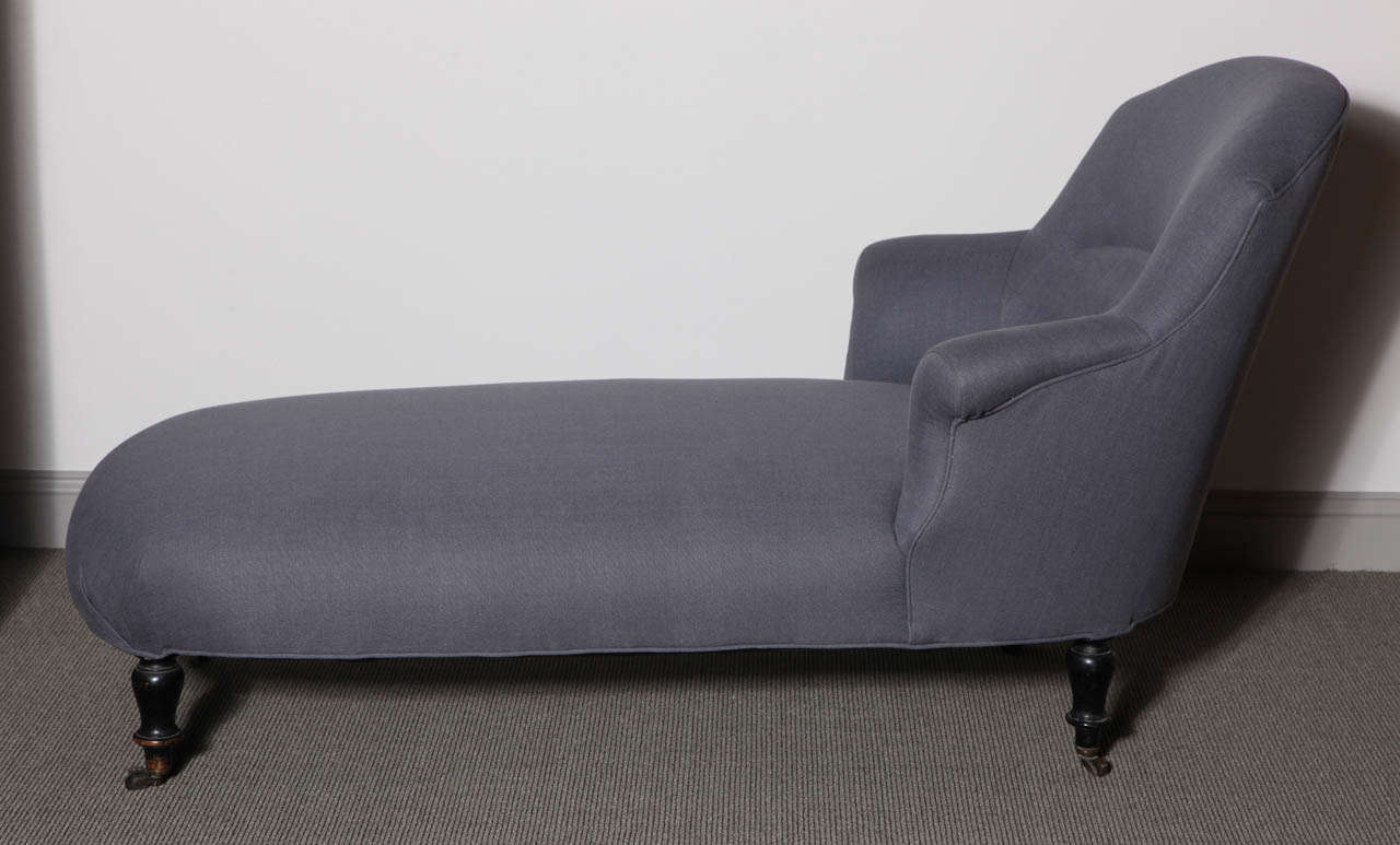 Napoleon III chaise with ebonized turned legs and original casters. It has curvaceous lines and is upholstered in linen.