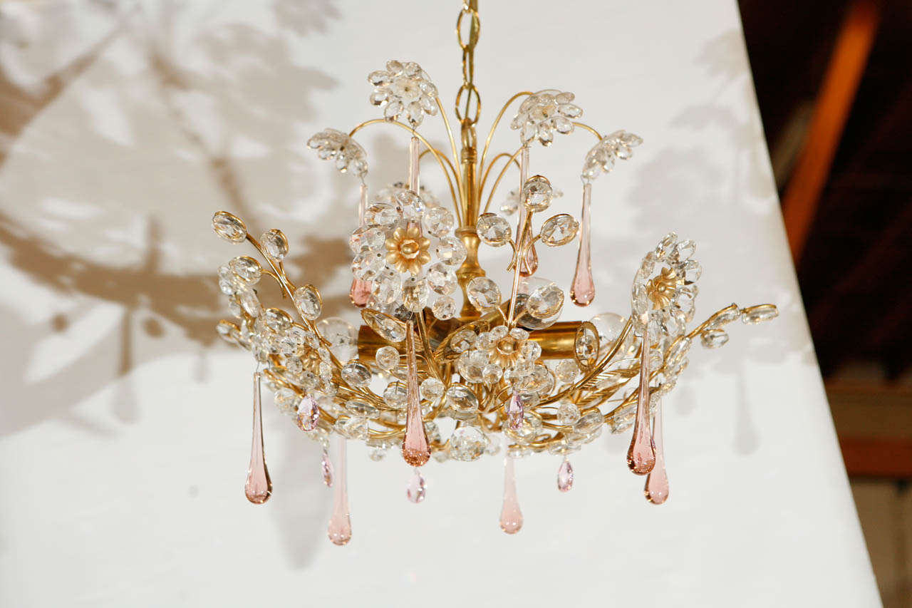 This beautiful little glass chandelier has a brass frame, crystal elements and pink blown glass droplets.  The delicate scale makes it a great find for a smaller setting. The chandelier has six lights, six flowers and six droplets with a brass