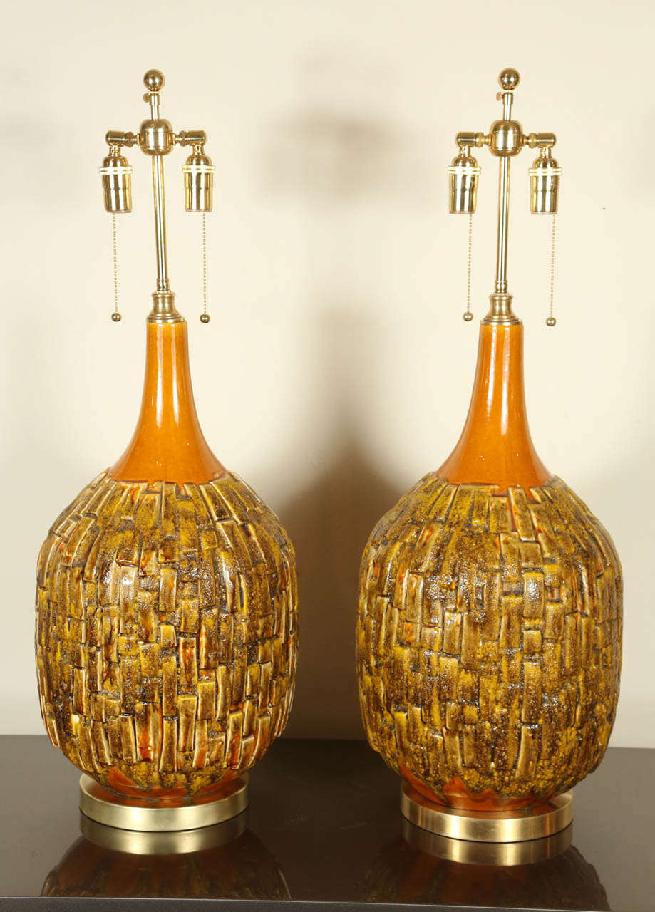 Pair of large stylish Mid-Century ceramic table lamps. They have been newly rewired and outfitted with brass bases and double cluster hardware.