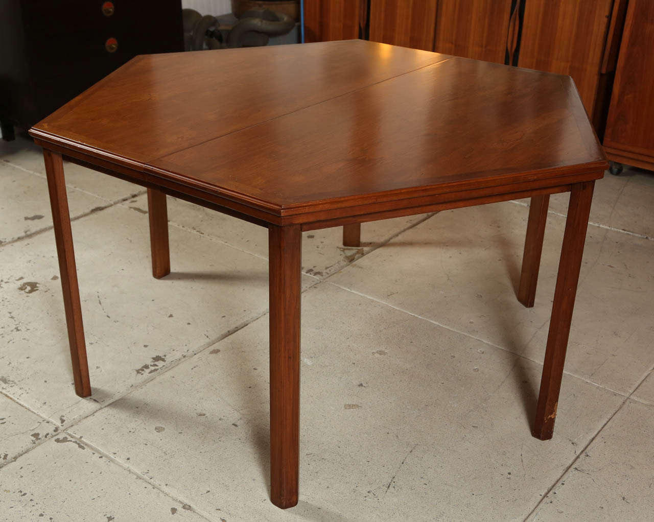 Custom hexagonal dining table with butterfly detail in walnut c.1962. Chairs are oil finished walnut with original woven fabric with lurex accents.