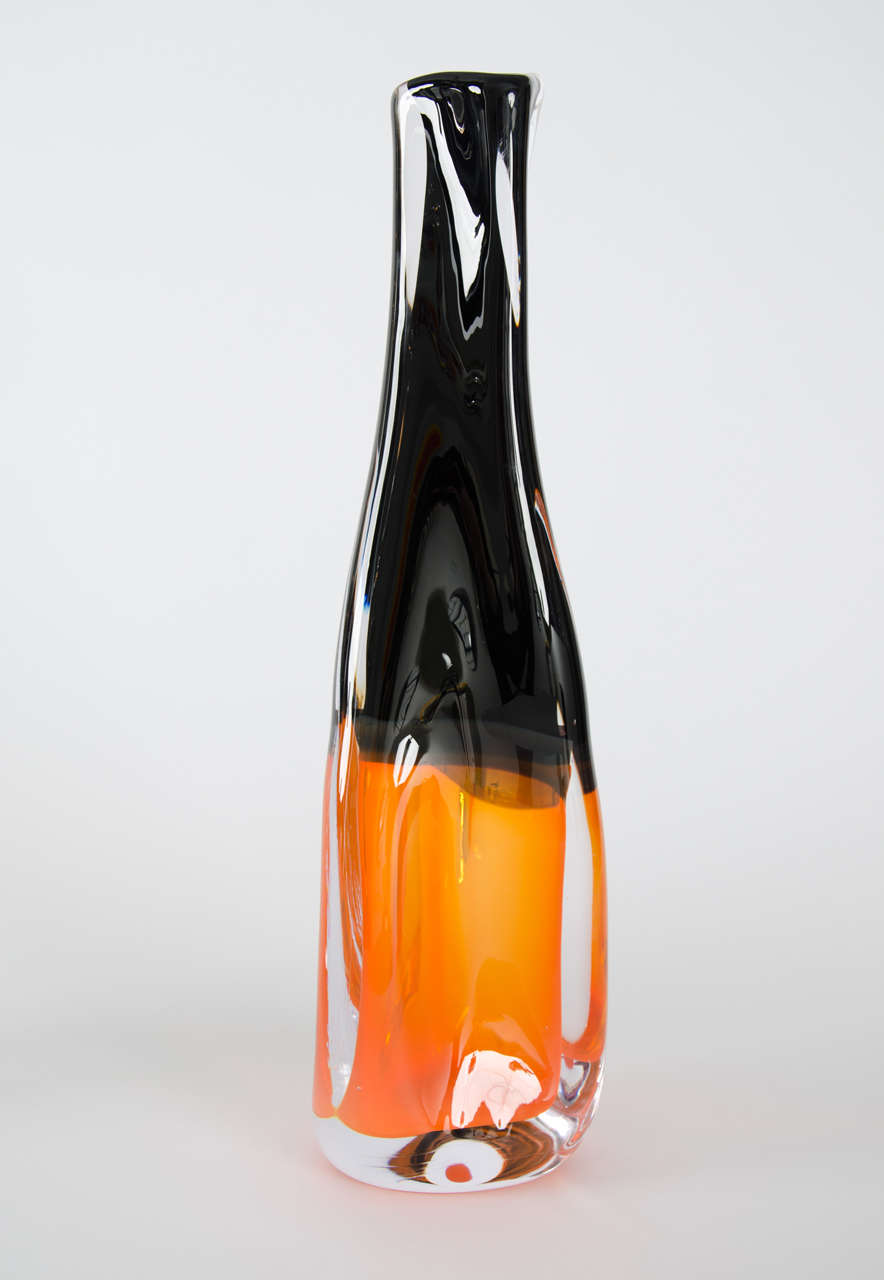 'Sommercalmo 83' is a unique handblown sculptural vase by the British artist Vic Bamforth. Striking black and orange meet and are encased in clear glass to create this stunning piece. With soft, twisting lines, the form has dynamic movement, which