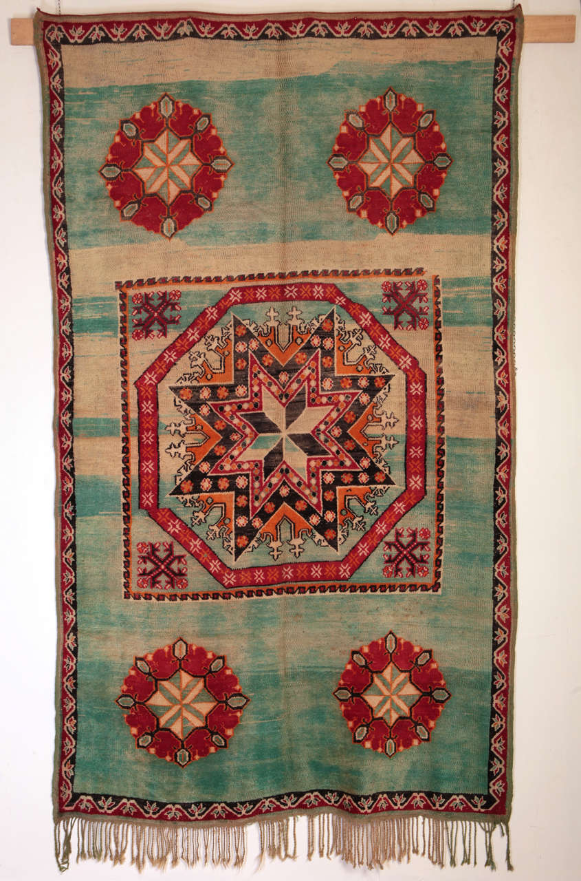 It is rare to see Berber weavings decorated by patterns that are not abstract but , like in this case, rather pictorial. The eight-pointed star contained within a large central octagon is a motif of Ottoman origin, like the quincunxial arrangement