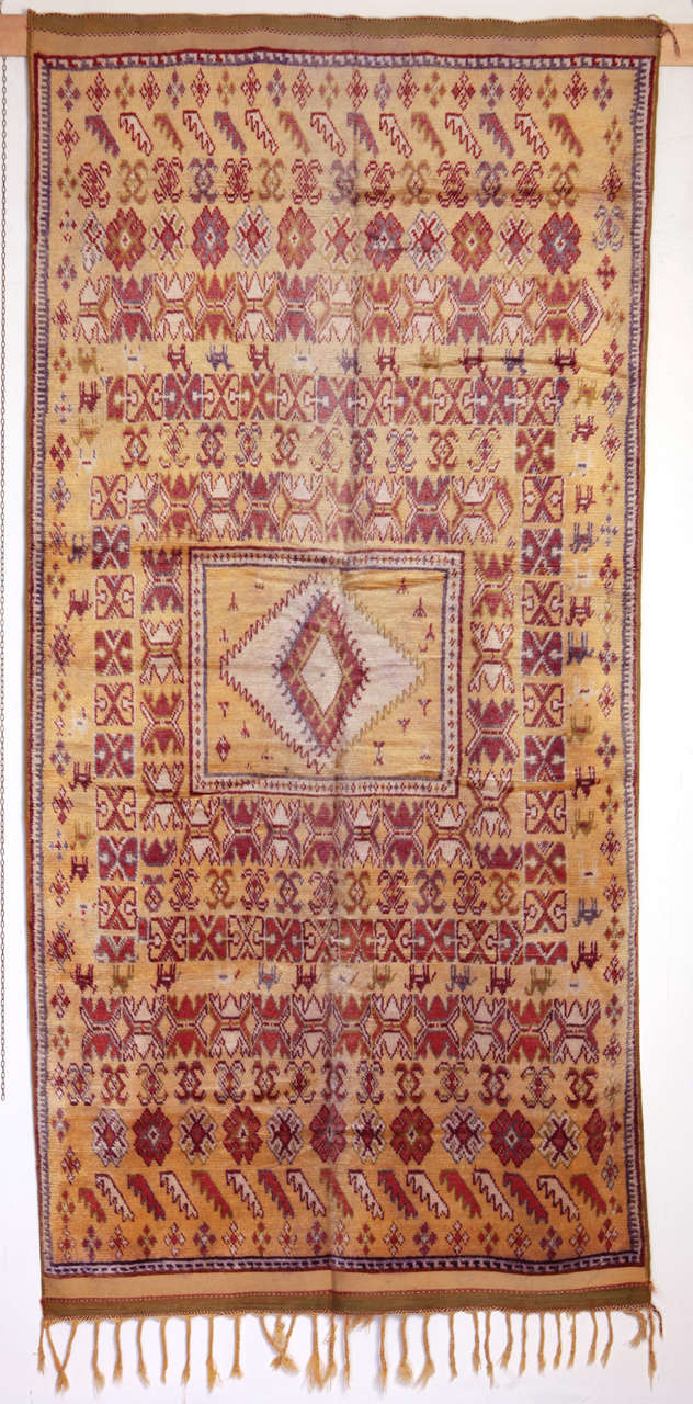 A rare soft yellow ground carpet from the Moroccan High Atlas. Carpets of this region are distinguished by a very fine weave and by a silky wool. This particular rug is in excellent condition, retaining the original end finishes and selvedge.