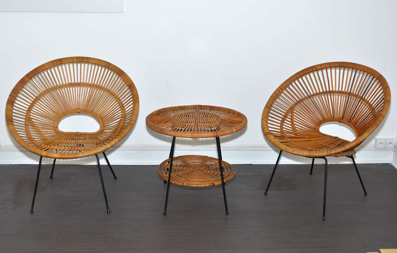 1950s set of two armchairs and a coffee table by Abraham & Roll, in rattan with metal legs. Coffee table height 60 cm., diameter 51 cm. Dimensions of armchairs are given below.