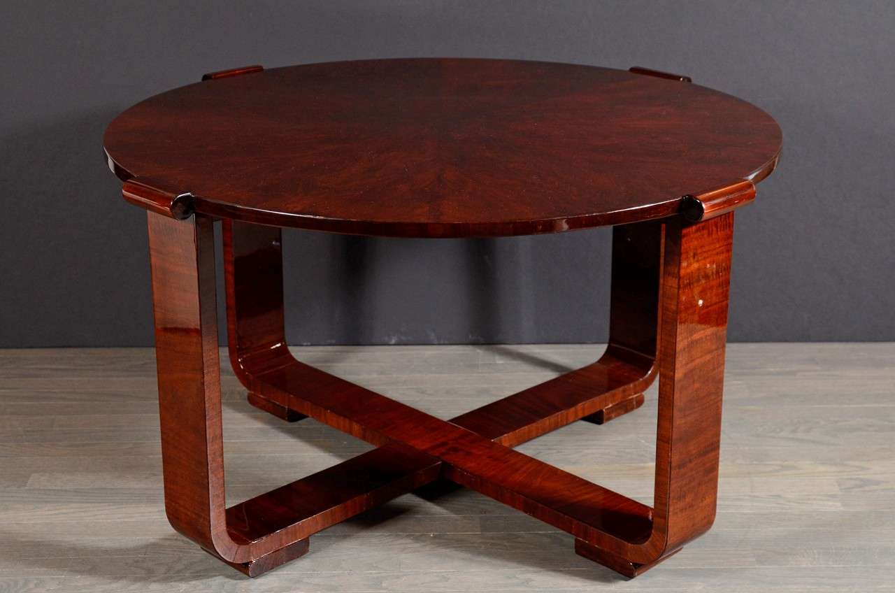 Realized in France, circa 1935 and composed of bookmatched exotic burled walnut, this dramatic Art Deco gueridon table features an X-form base design; square feet; and four rectangular arms that culminate in streamlined beveled scroll details, all