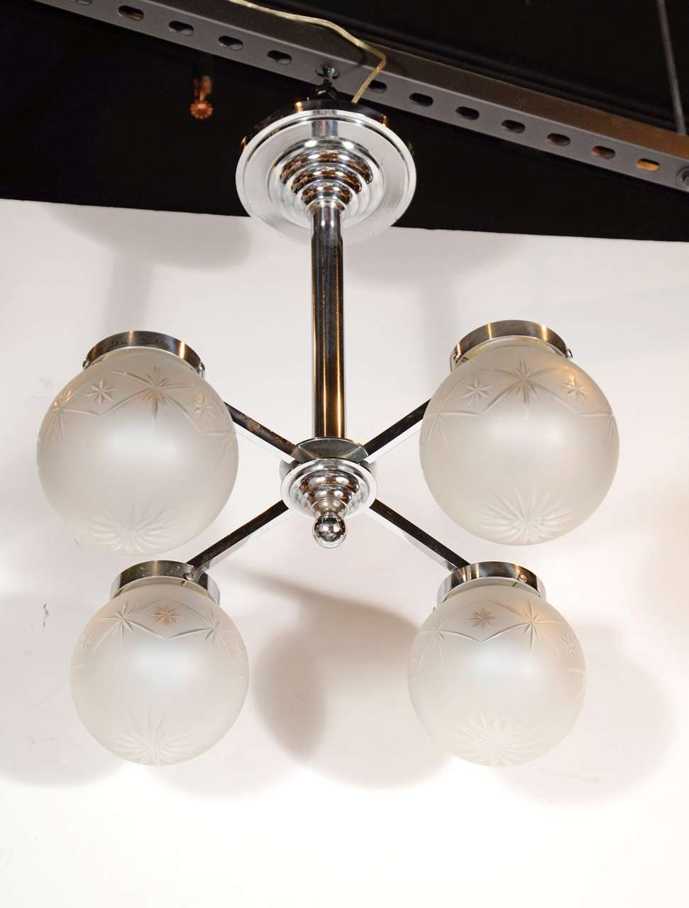 Art Deco chrome chandelier with skyscraper design fitted with four frosted glass globes, featuring etched starburst designs. Newly rewired to American standards. Excellent condition.

France, Circa 1930

Dimensions: 22