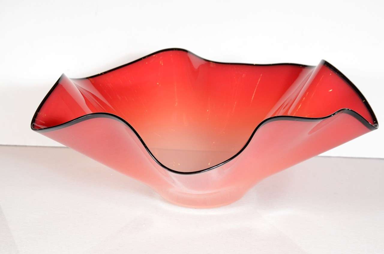 Stunning large red art glass bowl. This bowl features a fused black glass rim with a ruffled edge. Attributed to an artisan of the Chihuly Atelier.
