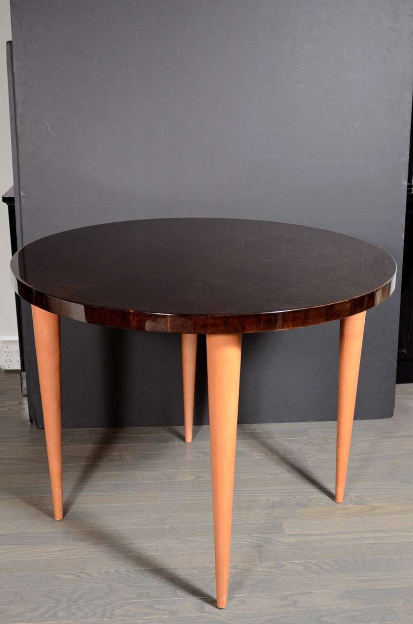 This occasional table by Gilbert Rhode features a bookmatched exotic burled walnut top with wrapped tan leather conical legs.