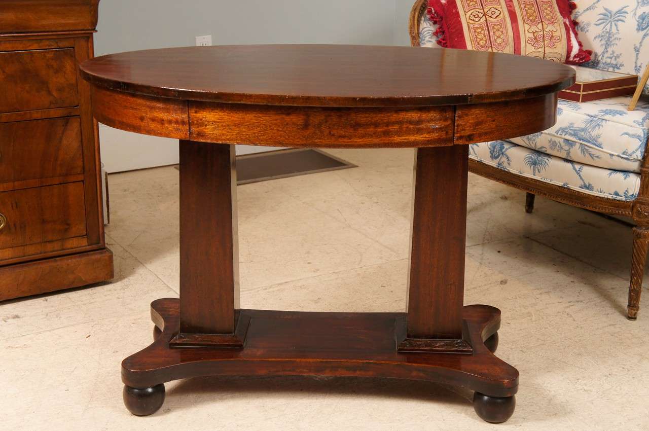Pillar and scroll mahogany Empire table with single drawer.