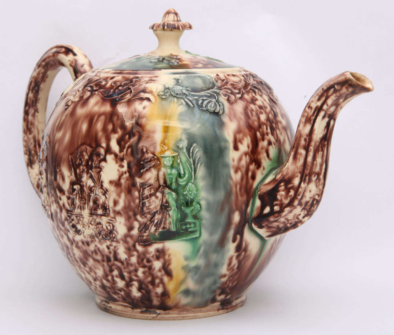 A rare unmarked  William Greatbatch pottery tortoise glaze teapot with Oriental figures in relief and decorated in underglaze oxide colors
