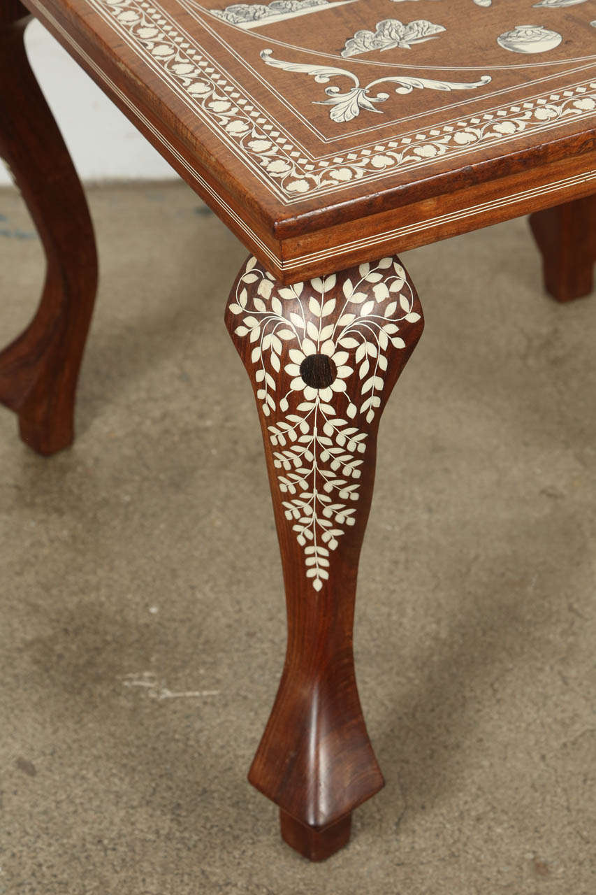 Anglo Indian Mughal teak inlaid side square table.
Fine and elegant Moorish table square shape inlaid end table with an elaborate Indian Mughal scene hand carved and bone inlay.
Size: 20 in. x 20 in square x 18 in Height.
Handmade in India circa