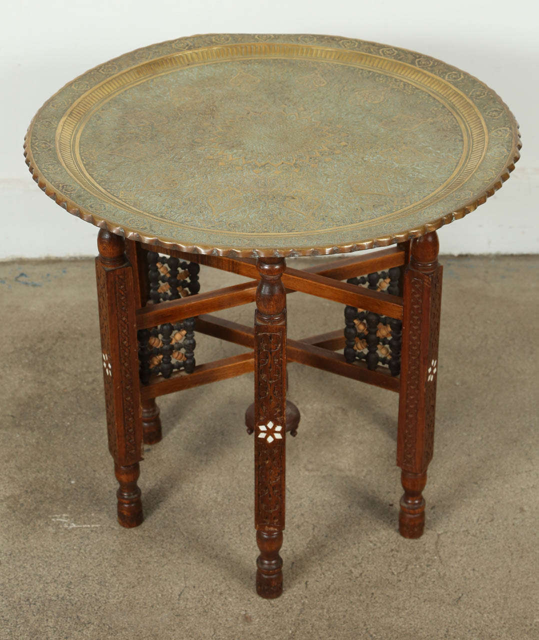Antique Persian Brass Tray on Folding Stand.
Amazing hand chiseled brass tray table, very fine intricate work on brass, sit on an antique wooden base carved and inlaid with mother of pearl and intricate fret work.