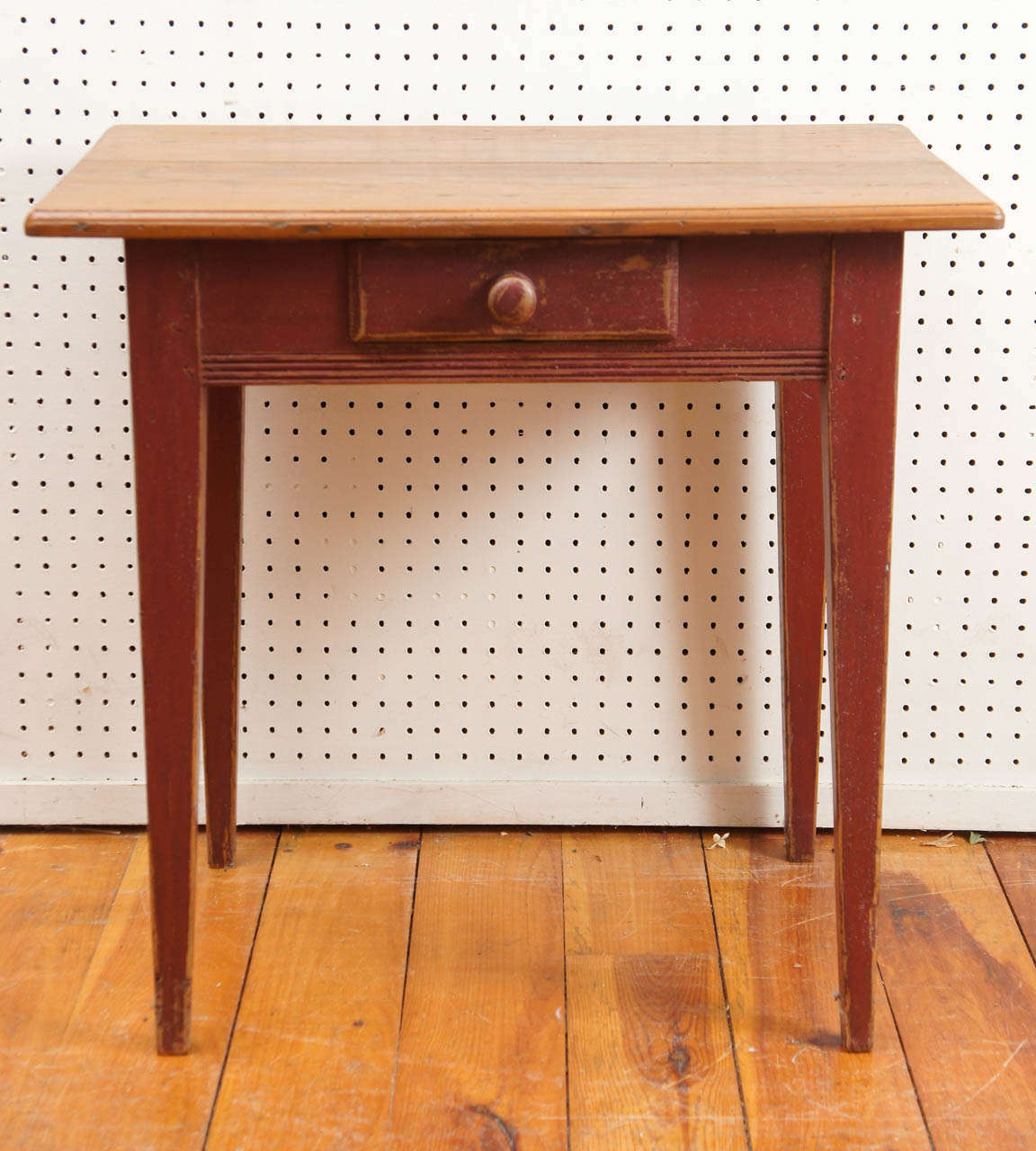 This nice little Canadian side table has a red base with tapered legs, reeding on the apron and a handy drawer on the front. The stained top accents the wonderful painted red base. A perfect side table or night stand.
