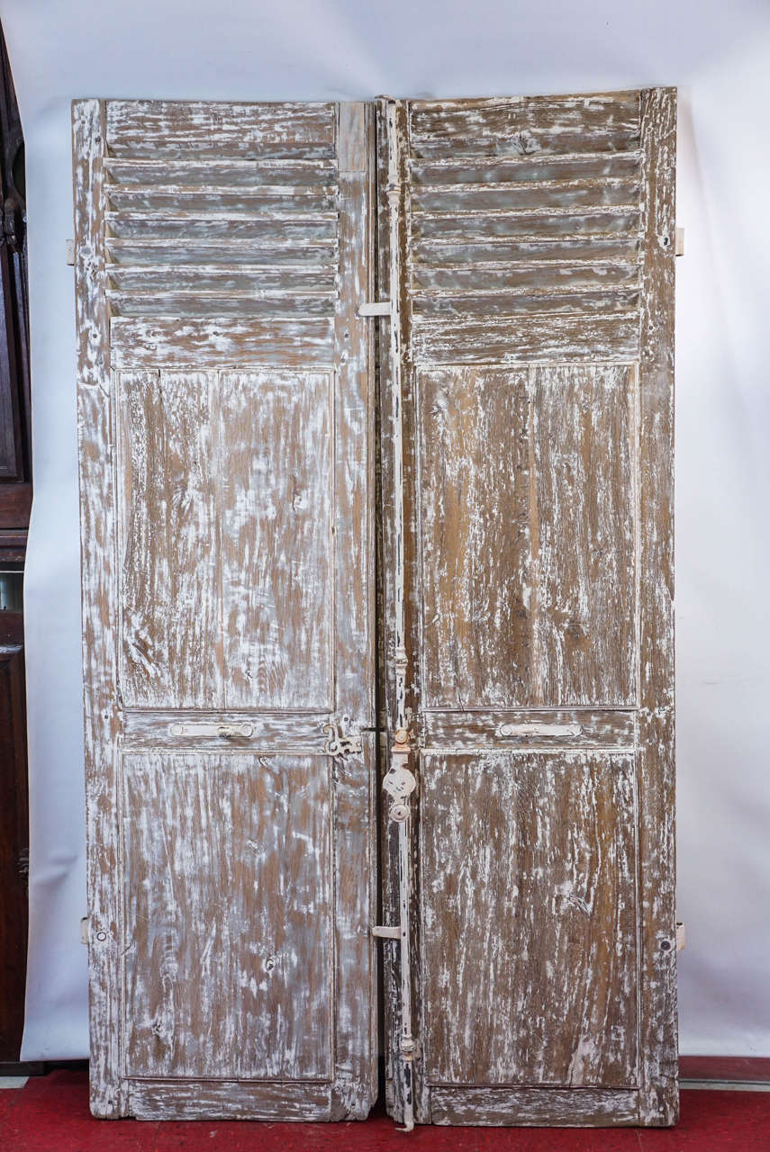 These substantial louvre shutters are well made with fitted moldings. Original full length cremone bolt iron bar latch swivels into place for locking. There is also a pair of center loop pulls for opening.
Dimensions are for each door.