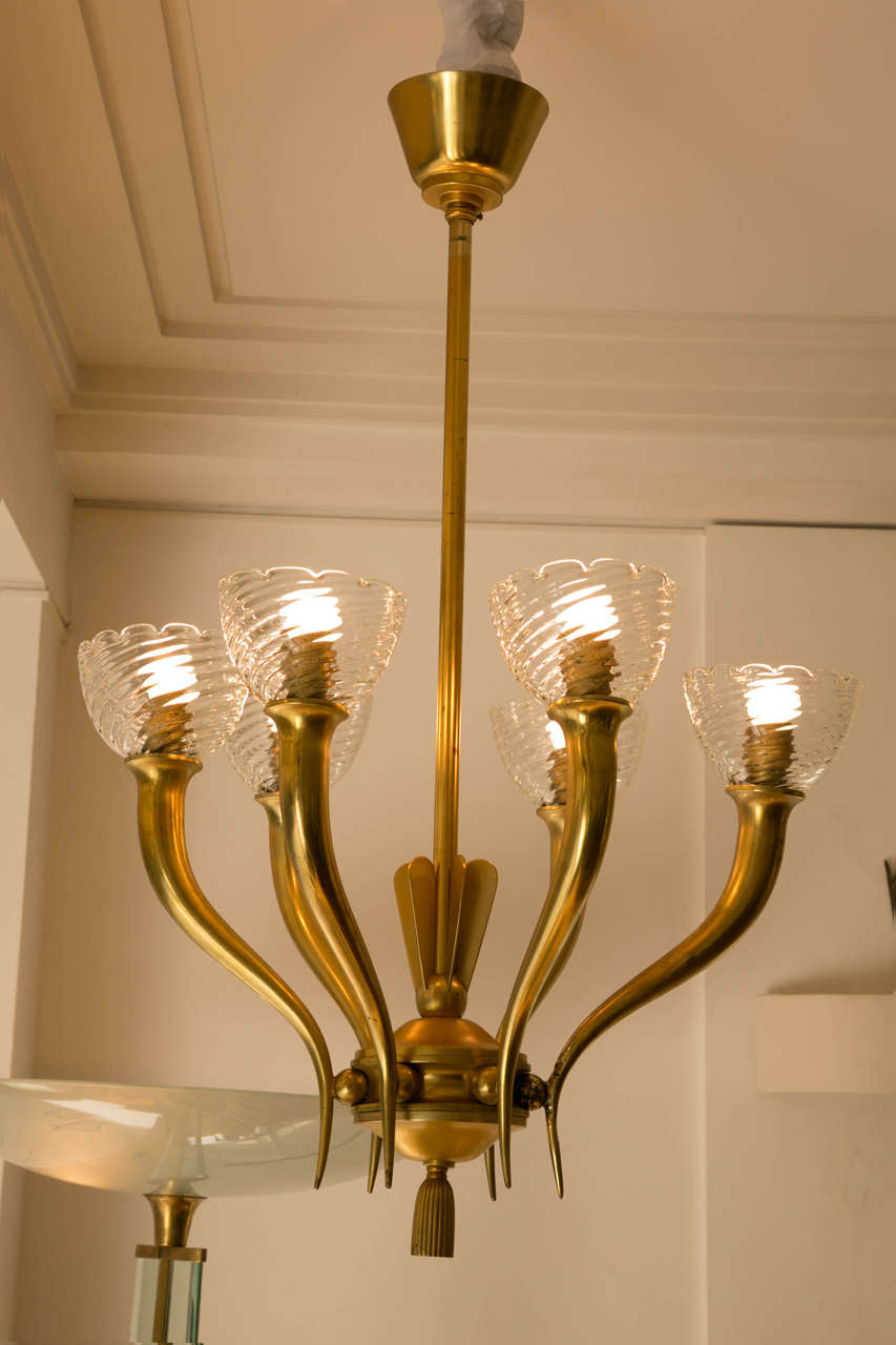 Gilt bronze and glass chandelier, Italy, 1960.
With six horn-arms and Seguso ondulated glass cups.

In a very Arbusian style.