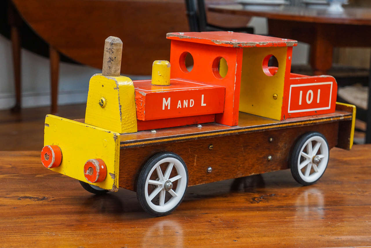 This colorful Red and yellow children's train will definitely get your attention. With white wheels and the M & L railroad lettering. Part of a much larger collection of children's toys at Painted Porch.
