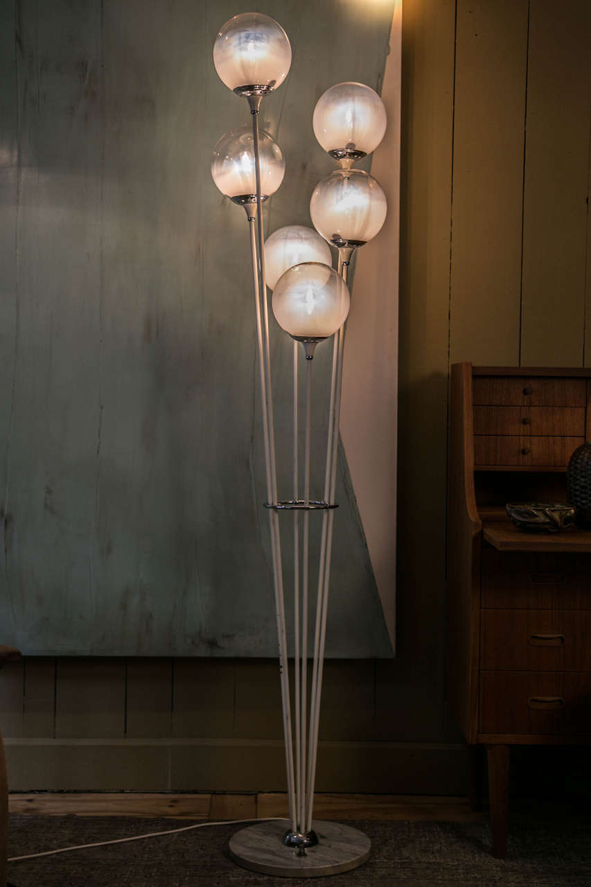 This floor lamp was designed by Stilnovo, Italy, circa 1965.
Six arms in lacquered metal are topped with semi white glass balls.
Arms are based on a round Carrara marble base with on/off switch allowing three different light positions. Very nice