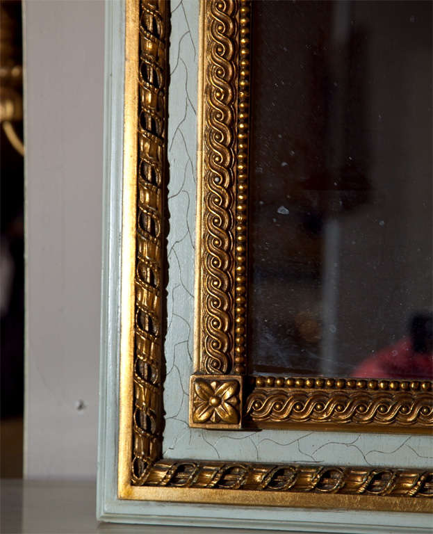 Painted French Louis XIV style trumeau mirror, 20th century, the frame with parcel-gilt annulated border, painted with crackle finish, decorated with urn and foliate.