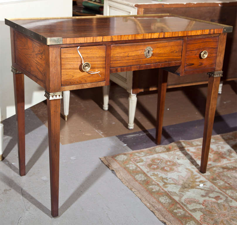 French Louis XVI style rosewood Lady's Desk, circa 1940s, rectangular top with bronze banding over a frieze fitted with three drawers decorated with round brass pulls, raised on four squared tapering legs.
