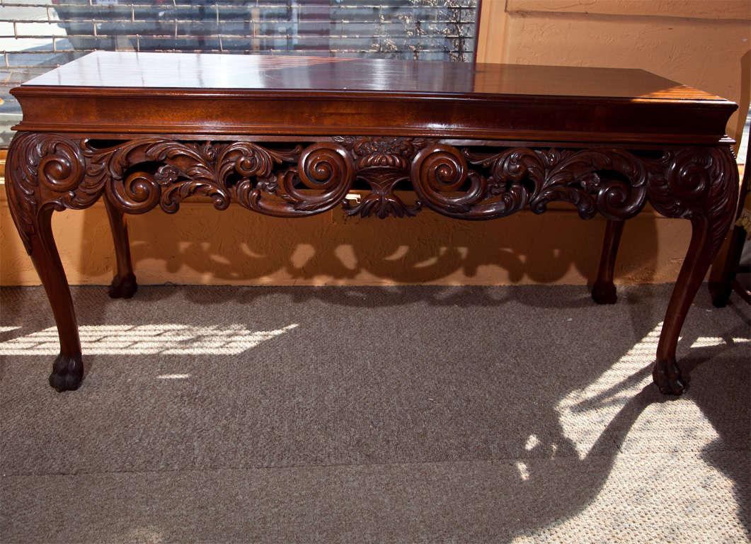 A finely carved pair of Georgian Style sideboard - console tables. The carved solid claw feet leading up to a carved cabriole curved leg supporting a nicely pierced carved apron leading to a concaved framed mahogany top. The rear of each console