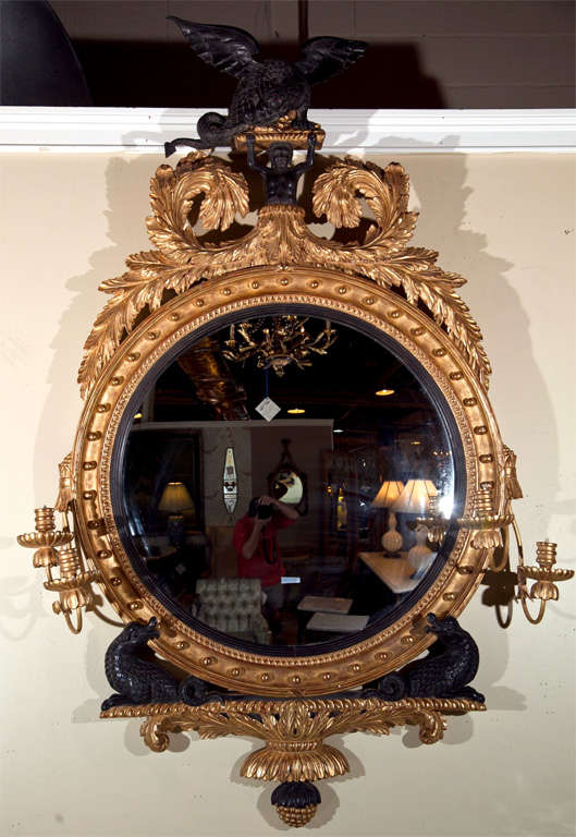 Federal style gilt-frame bull's eye convex mirror, possibly 2nd quarter of 20th century, beautiful annulated circular frame decorated with wreath crest and ebonized figurine holding a beast, each side of the frame has candlesticks arms, supported by