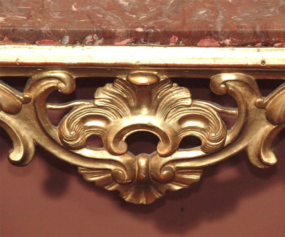 19th century Italian gilded console in the rococo taste, with rouge marble top