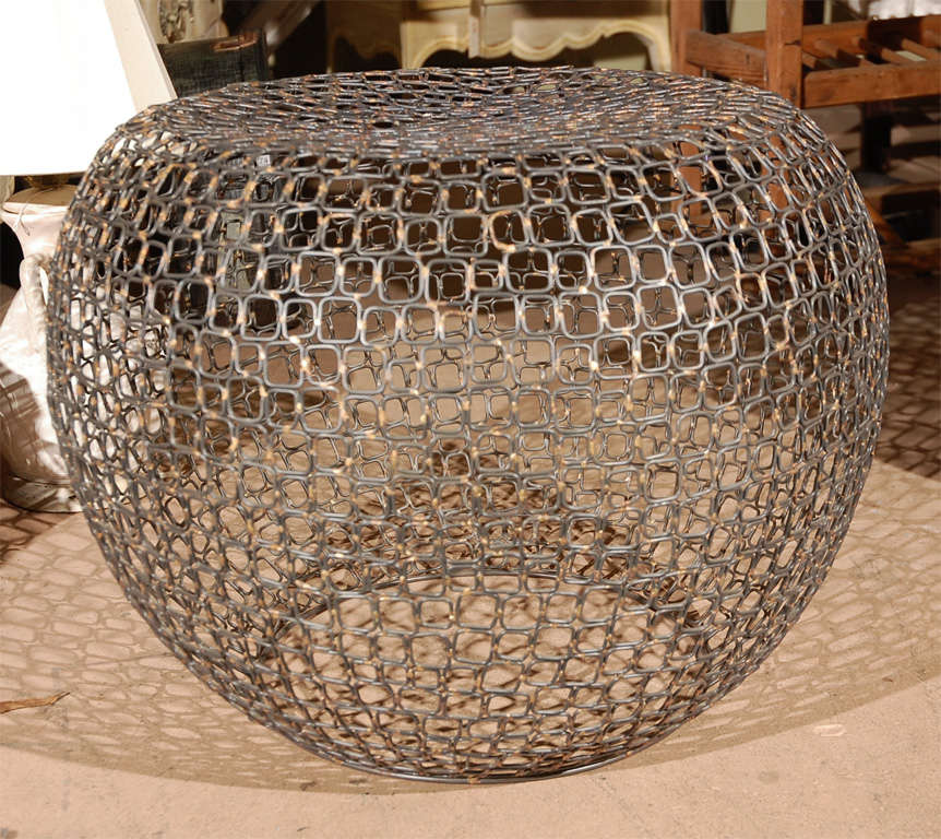 This ottoman/stool is not very old, but it sure has a great presence. Looks like a big metal beehive pattern--it is very comfortable and will hold a large person. Easy to move around, and has a high voltage design look. Just one of those pieces that