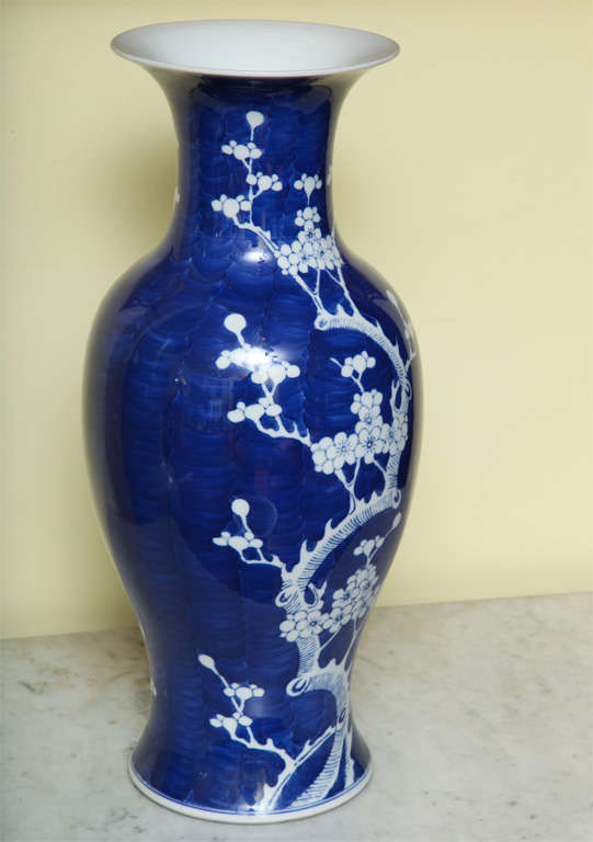 Finely formed Chinese blue and white baluster vase decorated with prunus branches and flowers on a watery blue ground with flared white lip and base, circa 1900.