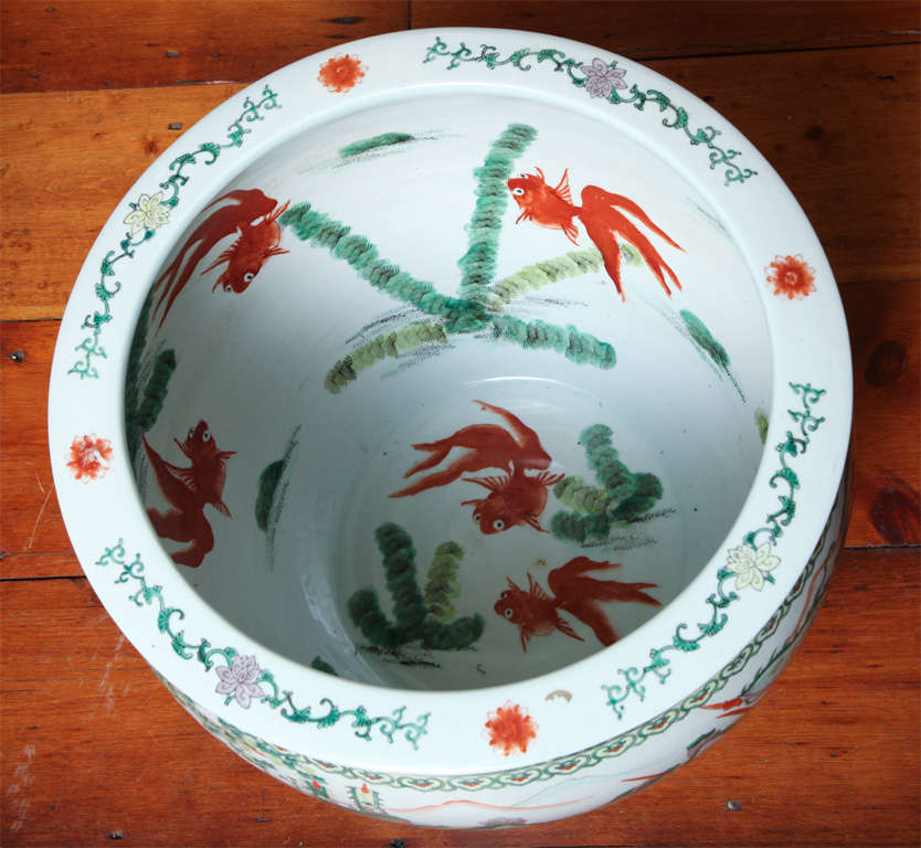 Large Chinese porcelain fishbowl/jardiniere with famille verte decoration with soldiers and horsemen with mountains to the rear on the outside and goldfish and plants on the inside of the bowl. With an inverted lip decorated in green and manganese.