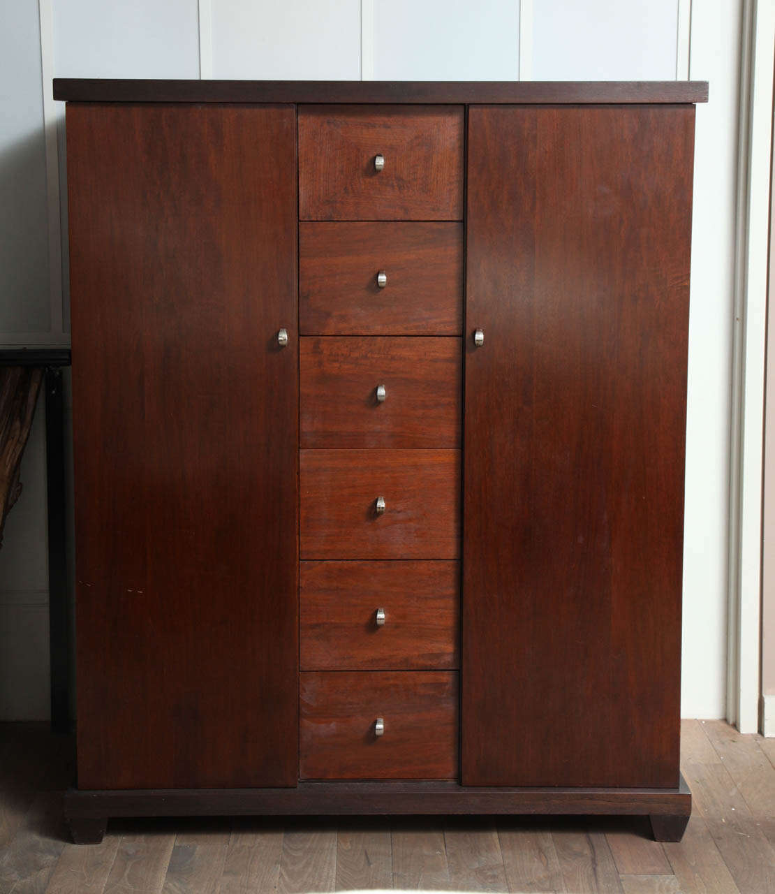 American of Martinsville chestnut finished wardrobe with mahogany doors and drawer fronts circa 1950 - central stack of six drawers is flanked by a cedar lined hanging cabinet on one side, additional drawers and tie rack on the other, polished