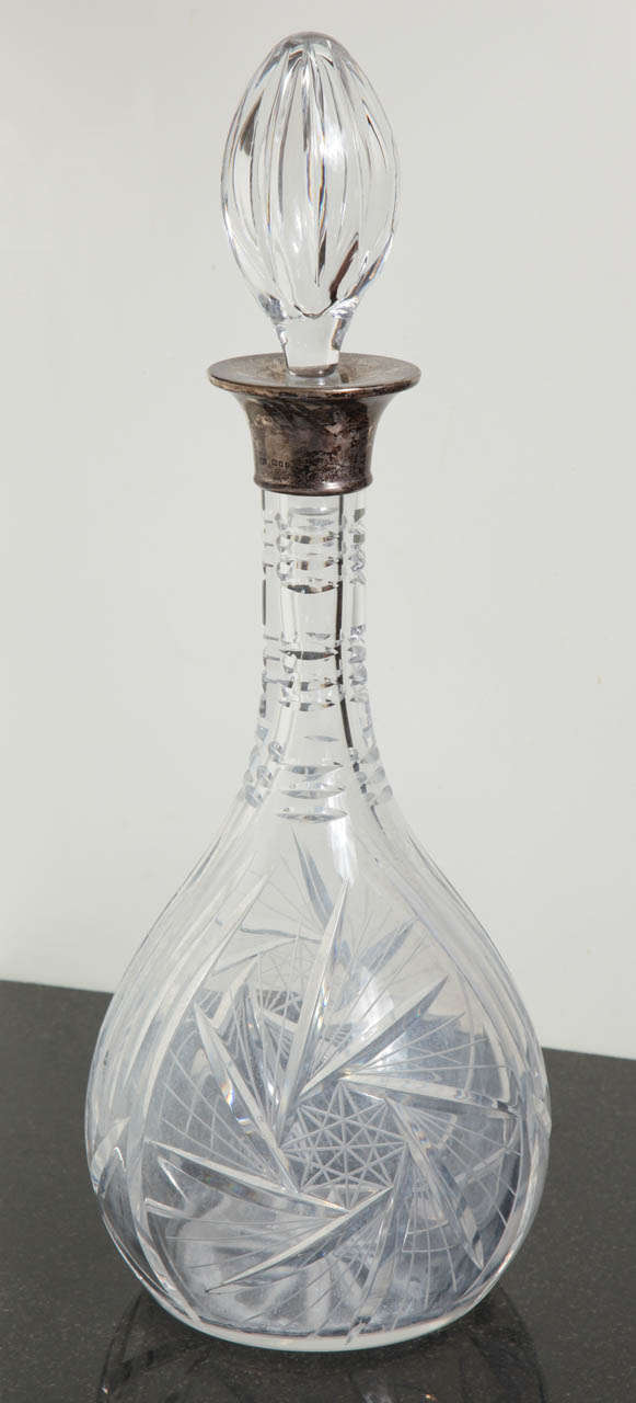 This Beautiful wine decanter is an English Antique by Robert Pringle and Sons.
The Cut Crystal and Sterling Silver accent makes this piece very classical and traditional. The piece exhales Art Deco. It has the hallmark in sterling silver ring at