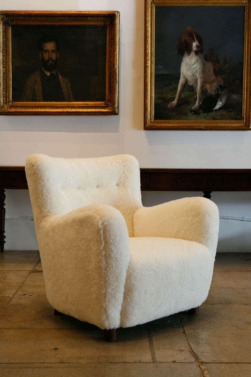Danish armchair upholstered in perfect snow-colored sheepskin. Two of two from the same property. Sold separately.