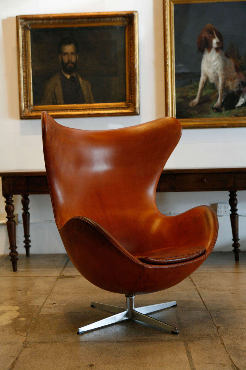 An early cognac egg chair designed by Arne Jacobsen and produced by Fritz Hansen. Original cognac leather and condition.