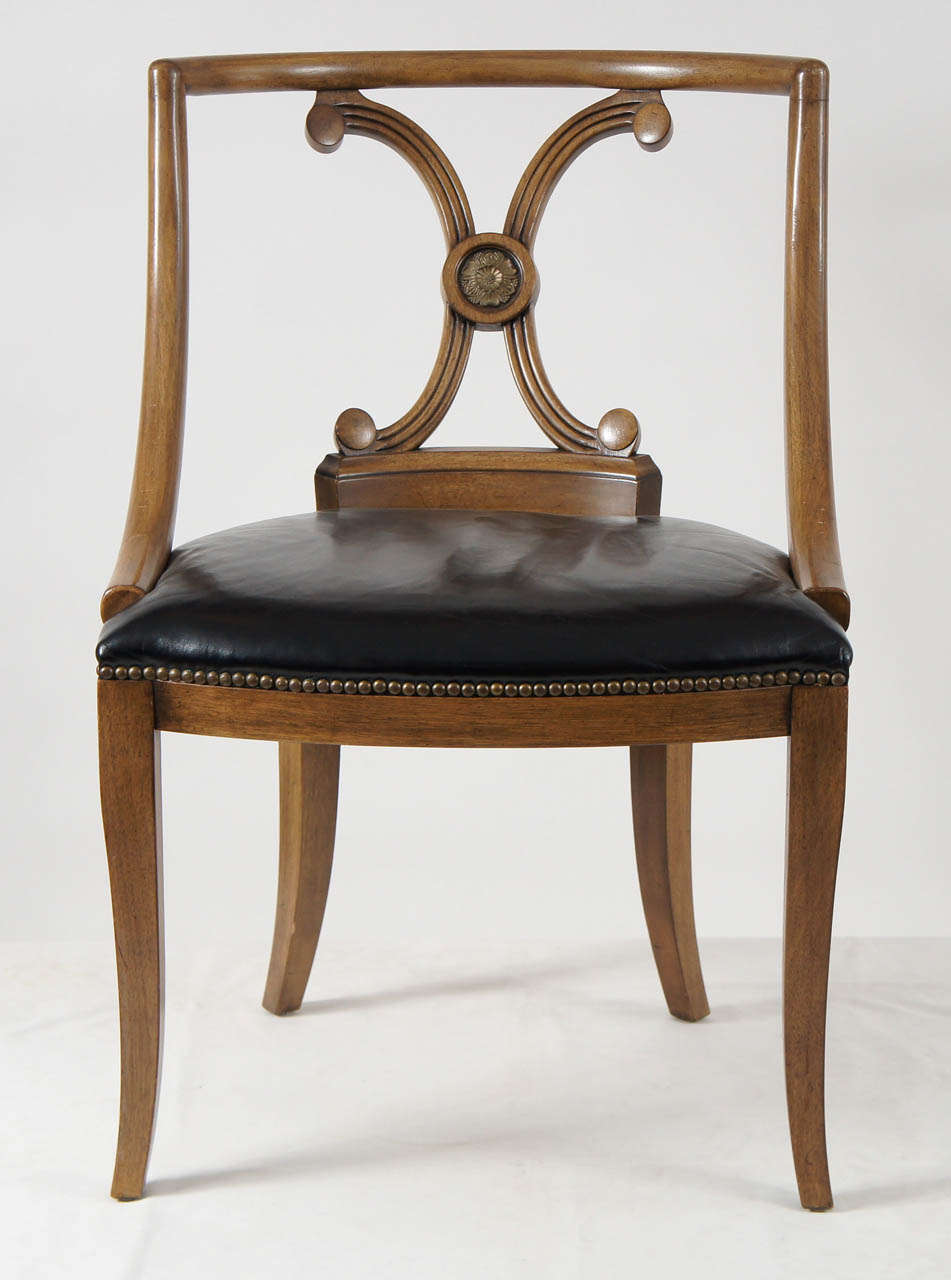 A rare and decorative set of six John Stuart designed dining chairs in the Neoclassical style in original black leather upholstery and nailhead trim detail.