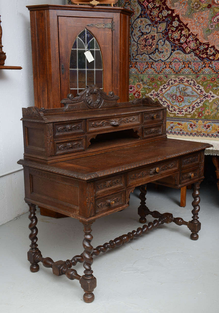 Well hand carved & detailed in oak, this desk has 10 drawers with original wooden pulls.  The desk portion is 30.5